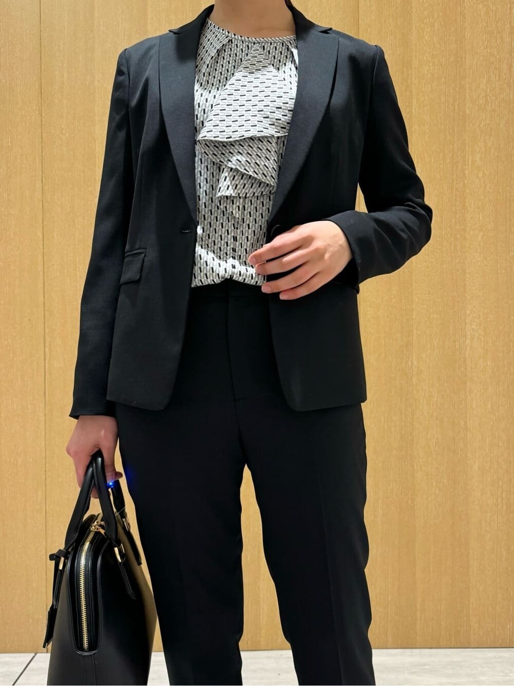 ブラック系のテーラードジャケット、ブラック系のその他パンツ、ブラック系のパンプスを着用したレディースの冬コーディネートの6枚目の写真
