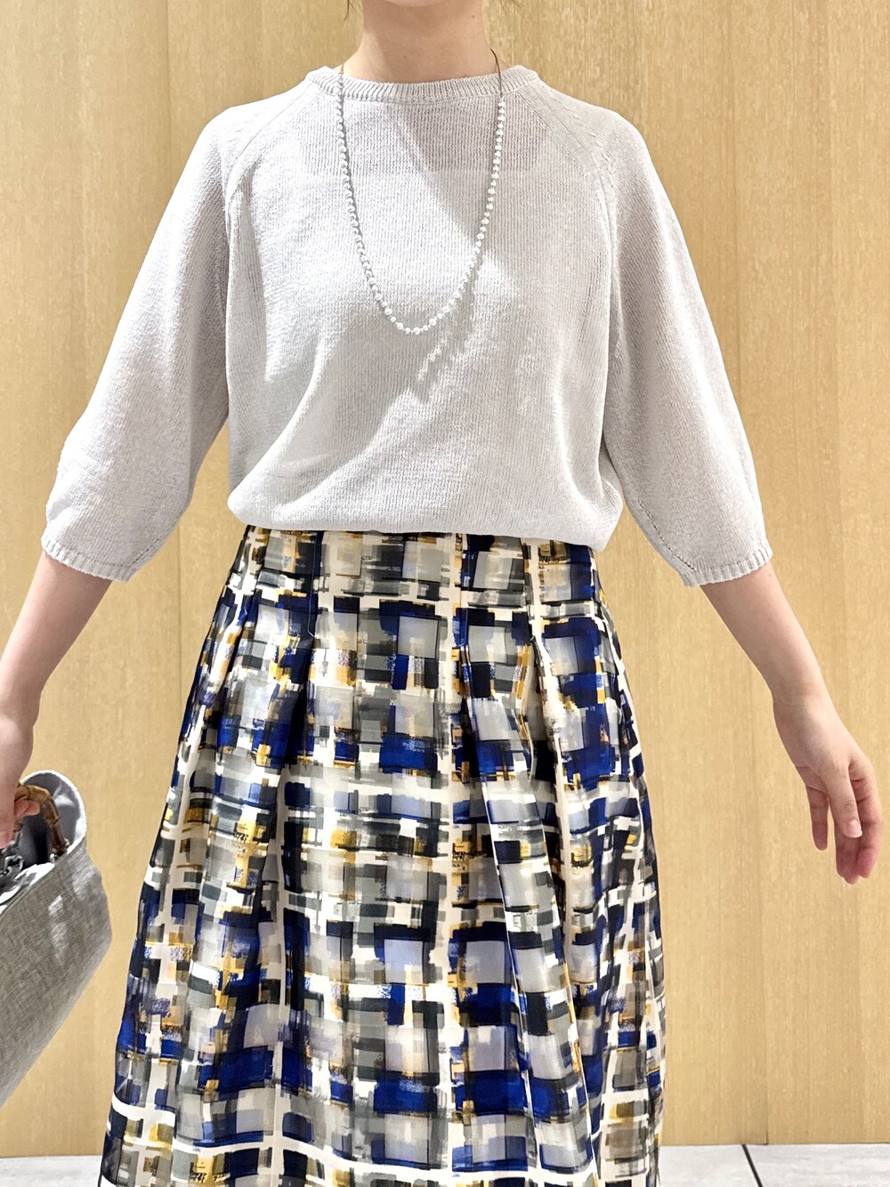 グレー系のニット/セーター、ホワイト系のタンクトップを着用したレディースの夏コーディネートの5枚目の写真