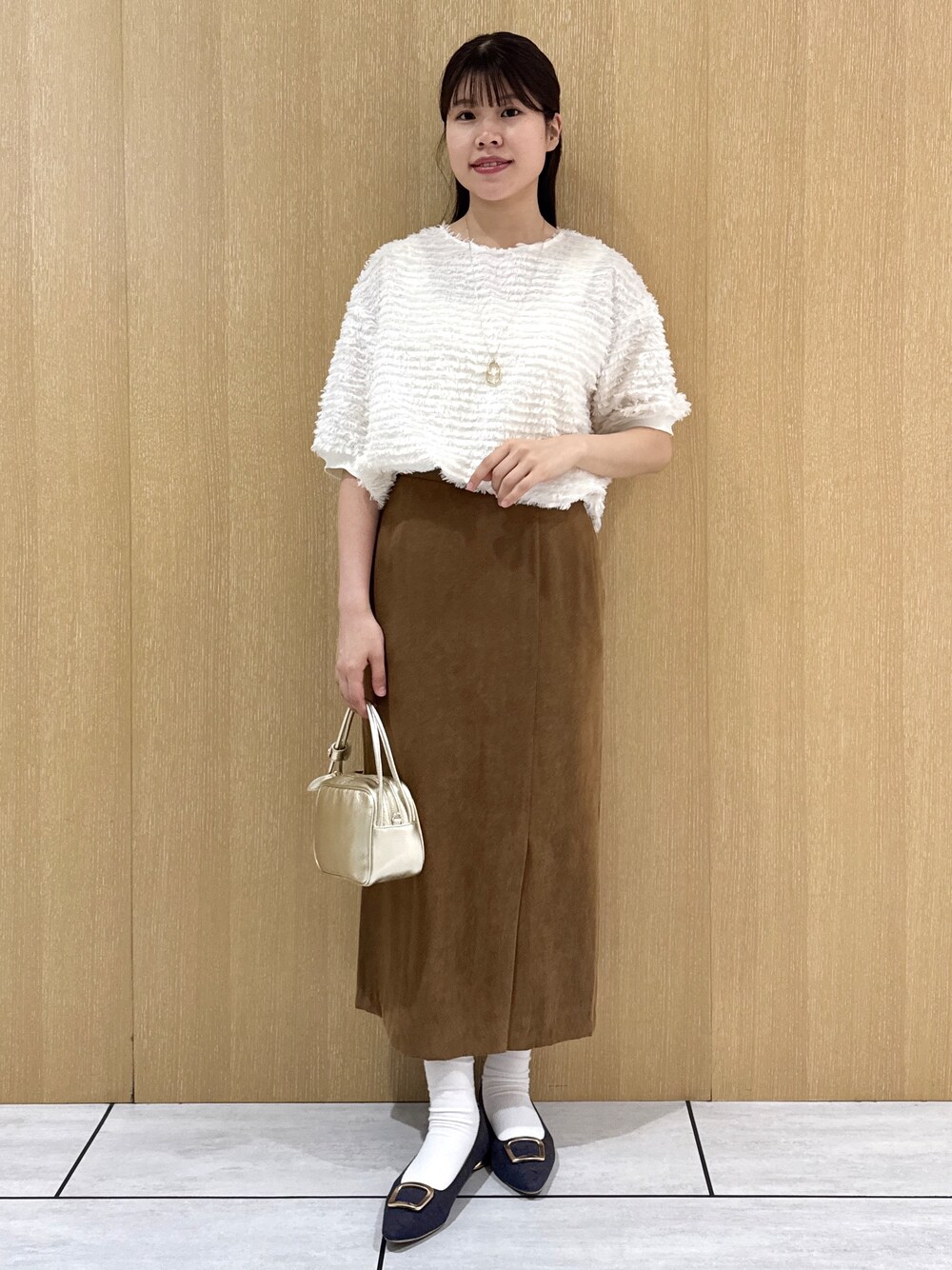 ホワイト系のTシャツ/カットソー、イエロー系のスカートを着用したレディースの秋コーディネートの2枚目の写真