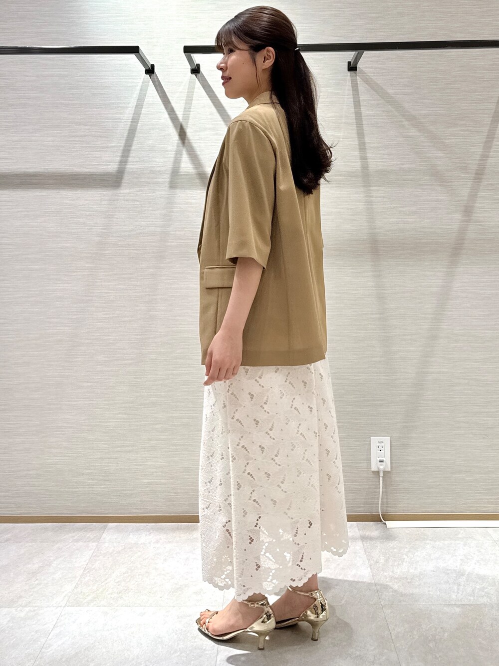 イエロー系のテーラードジャケット、ブラック系のTシャツ/カットソー、ホワイト系のスカートを着用したレディースの秋コーディネートの7枚目の写真