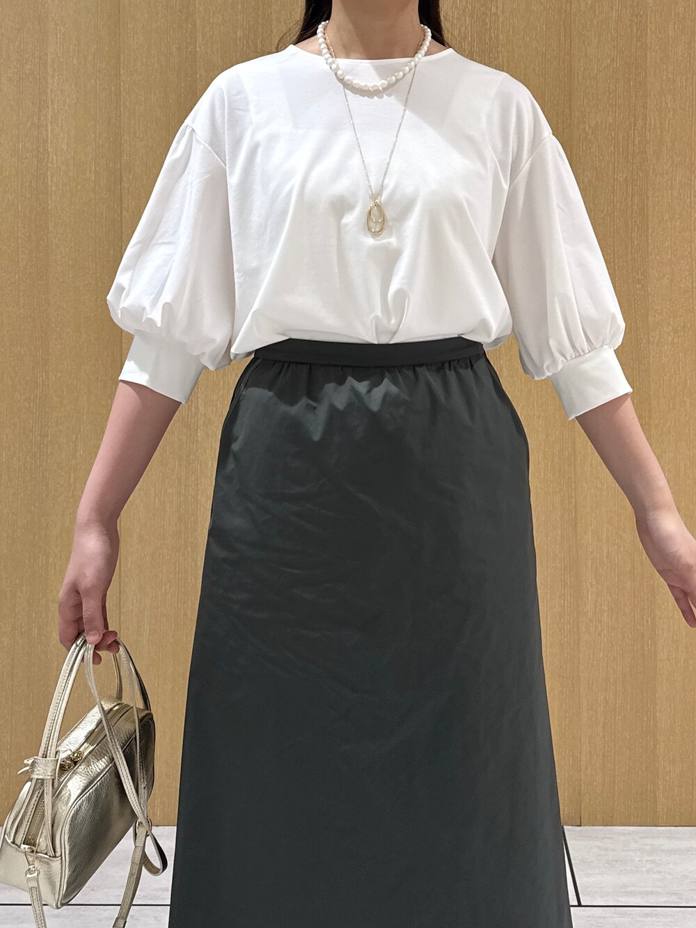ホワイト系のTシャツ/カットソー、グリーン系のスカートを着用したレディースの秋コーディネートの7枚目の写真