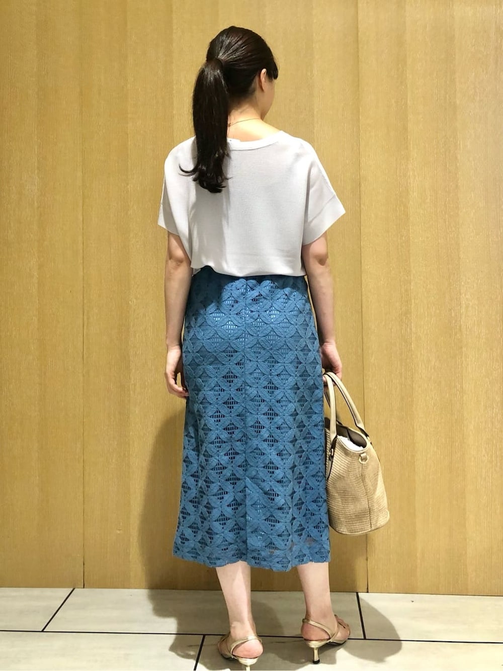 グレー系のニット/セーター、ブルー系のスカートを着用したレディースの夏コーディネートの3枚目の写真