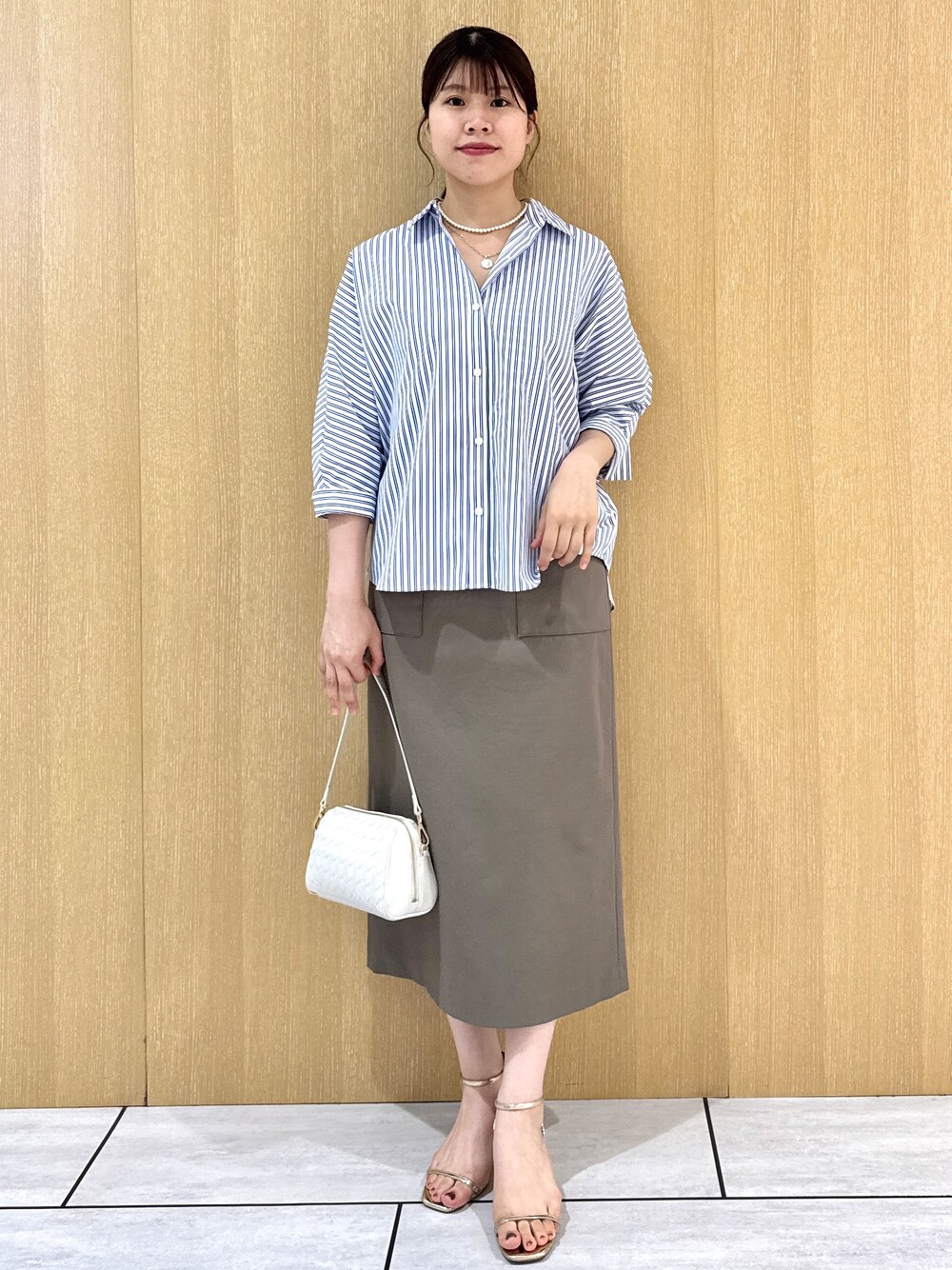 ブルー系のシャツ/ブラウス、グリーン系のスカートを着用したレディースの夏コーディネートの7枚目の写真