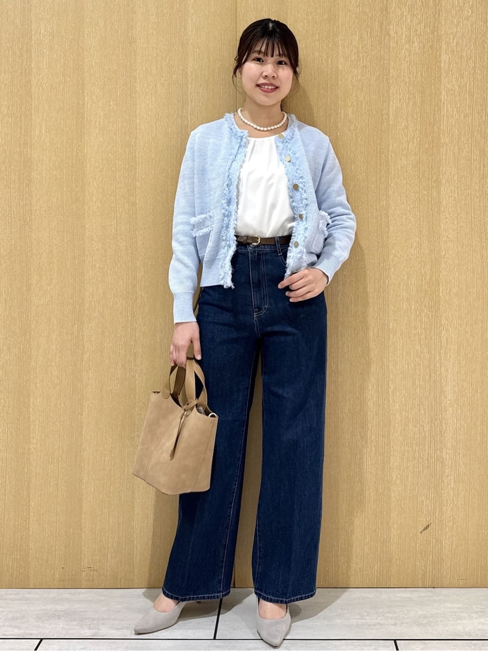 ベージュ系のトートバッグ、ブルー系のデニムパンツ、ホワイト系のシャツ/ブラウスを着用したレディースの春コーディネートの6枚目の写真