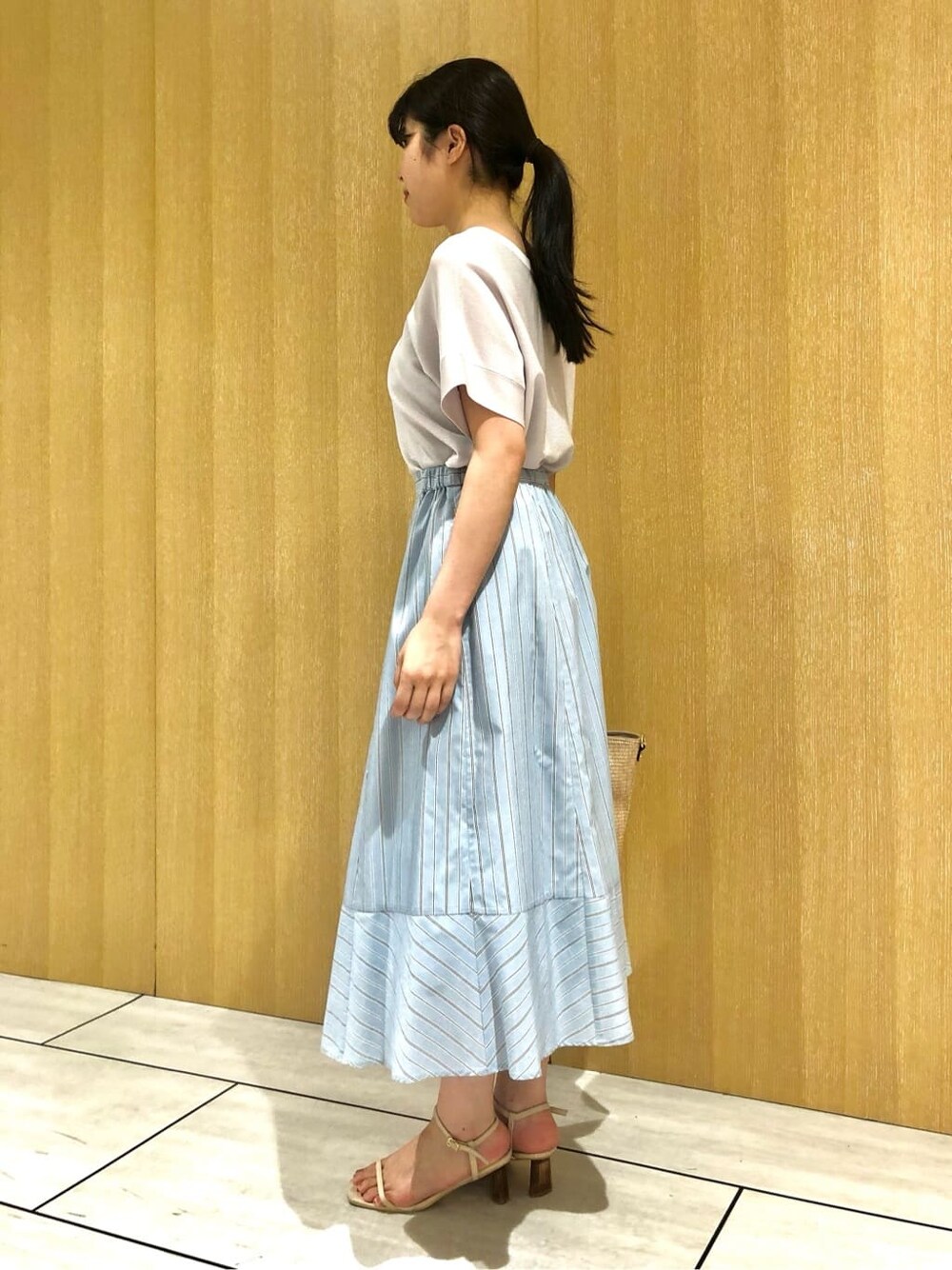 グレー系のニット/セーター、ブルー系のスカートを着用したレディースの夏コーディネートの3枚目の写真