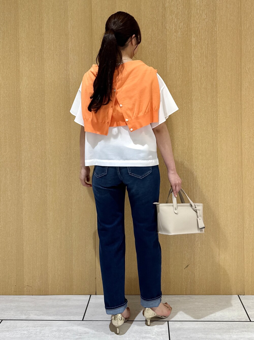 ホワイト系のシャツ/ブラウス、オレンジ系のカーディガン/ボレロ、ブルー系のデニムパンツを着用したレディースの夏コーディネートの3枚目の写真