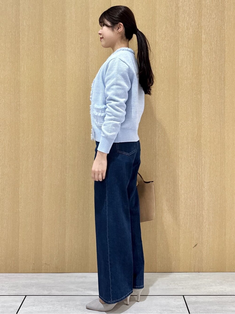 ベージュ系のトートバッグ、ブルー系のデニムパンツ、ホワイト系のシャツ/ブラウスを着用したレディースの春コーディネートの2枚目の写真