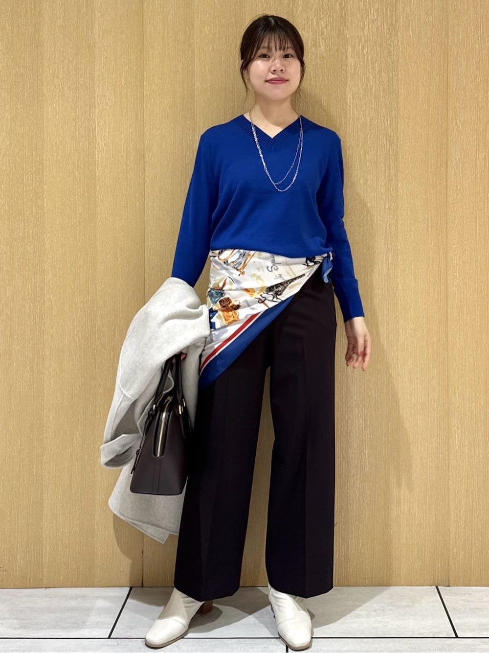 ブルー系のニット/セーター、ブラウン系のその他パンツ、ベージュ系のチェスターコートを着用したレディースの冬コーディネートの6枚目の写真