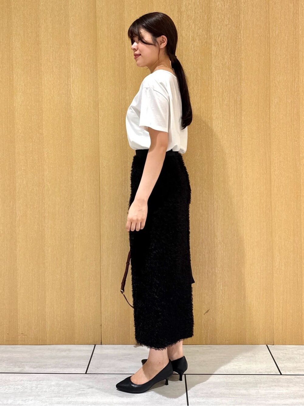 ブラック系のベスト、ホワイト系のTシャツ/カットソー、ブラウン系のスカートを着用したレディースの夏コーディネートの3枚目の写真