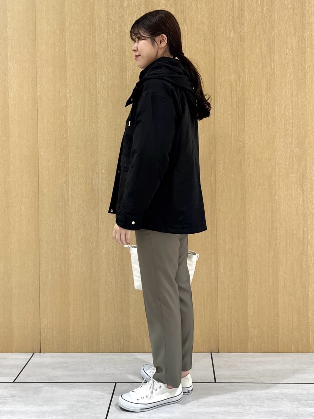 ブラック系のブルゾン、イエロー系のニット/セーター、ベージュ系のその他パンツを着用したレディースの秋コーディネートの2枚目の写真
