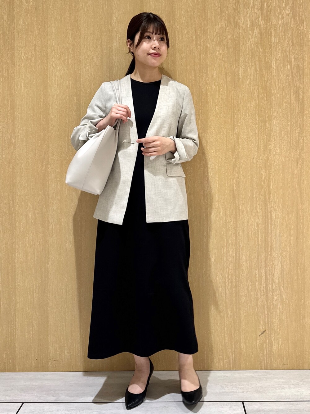 ブラック系のワンピース、ベージュ系のノーカラージャケットを着用したレディースの夏コーディネートの8枚目の写真