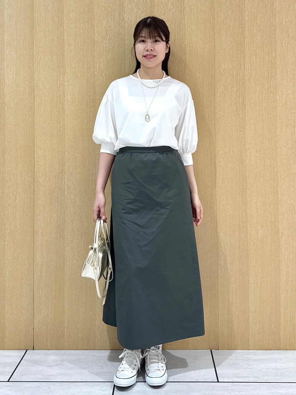 ホワイト系のTシャツ/カットソー、グリーン系のスカートを着用したレディースの秋コーディネートの10枚目の写真