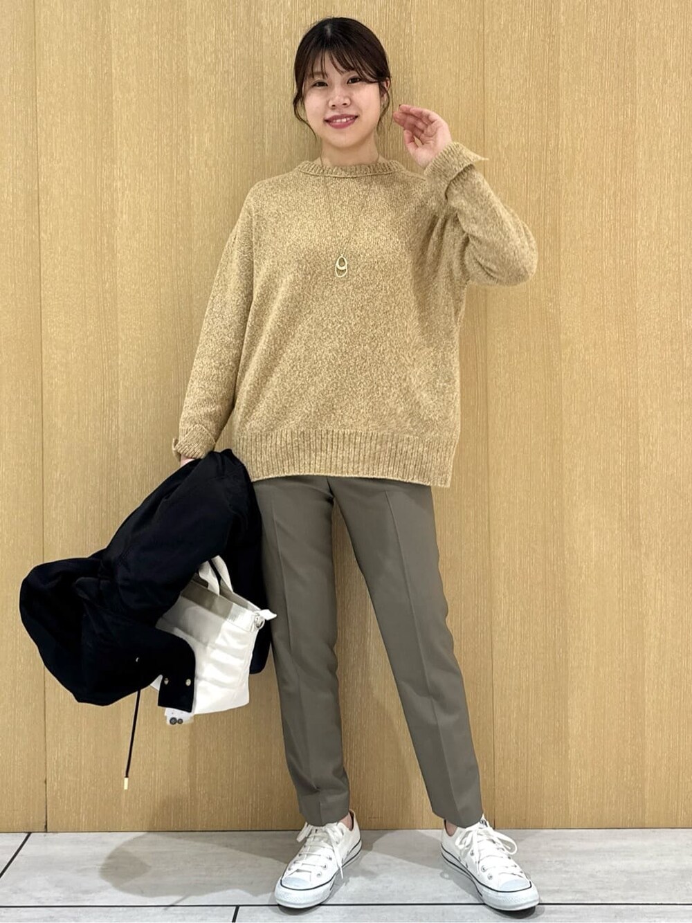 イエロー系のニット/セーター、ベージュ系のその他パンツ、ブラック系のブルゾンを着用したレディースの秋コーディネートの10枚目の写真