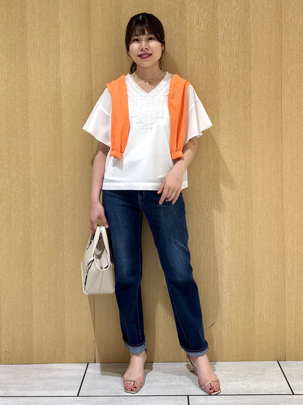 ホワイト系のシャツ/ブラウス、オレンジ系のカーディガン/ボレロ、ブルー系のデニムパンツを着用したレディースの夏コーディネートの7枚目の写真