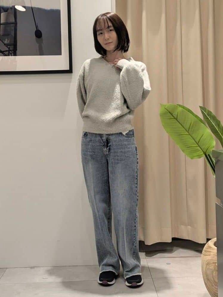 ベージュ系のニット/セーター、ブルー系のデニムパンツ、ブラック系のショルダーバッグを着用したレディースの秋コーディネートの6枚目の写真