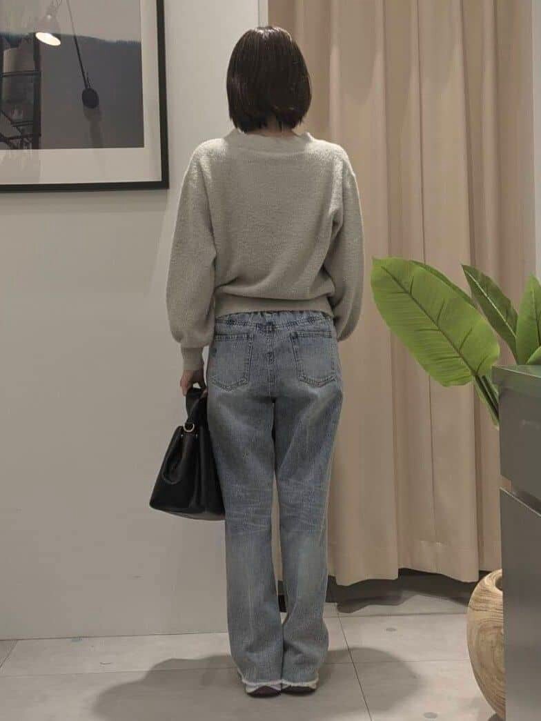 ベージュ系のニット/セーター、ブルー系のデニムパンツ、ブラック系のショルダーバッグを着用したレディースの秋コーディネートの5枚目の写真
