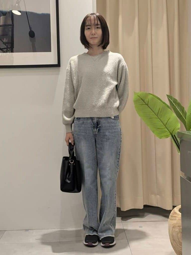 ベージュ系のニット/セーター、ブルー系のデニムパンツ、ブラック系のショルダーバッグを着用したレディースの秋コーディネートの3枚目の写真