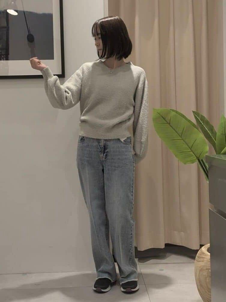 ベージュ系のニット/セーター、ブルー系のデニムパンツ、ブラック系のショルダーバッグを着用したレディースの秋コーディネートの7枚目の写真