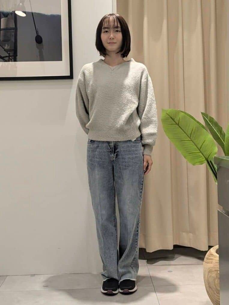 ベージュ系のニット/セーター、ブルー系のデニムパンツ、ブラック系のショルダーバッグを着用したレディースの秋コーディネートの8枚目の写真
