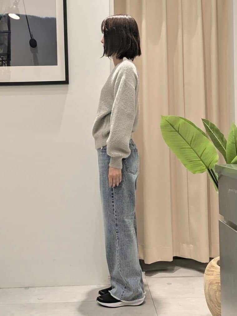 ベージュ系のニット/セーター、ブルー系のデニムパンツ、ブラック系のショルダーバッグを着用したレディースの秋コーディネートの9枚目の写真