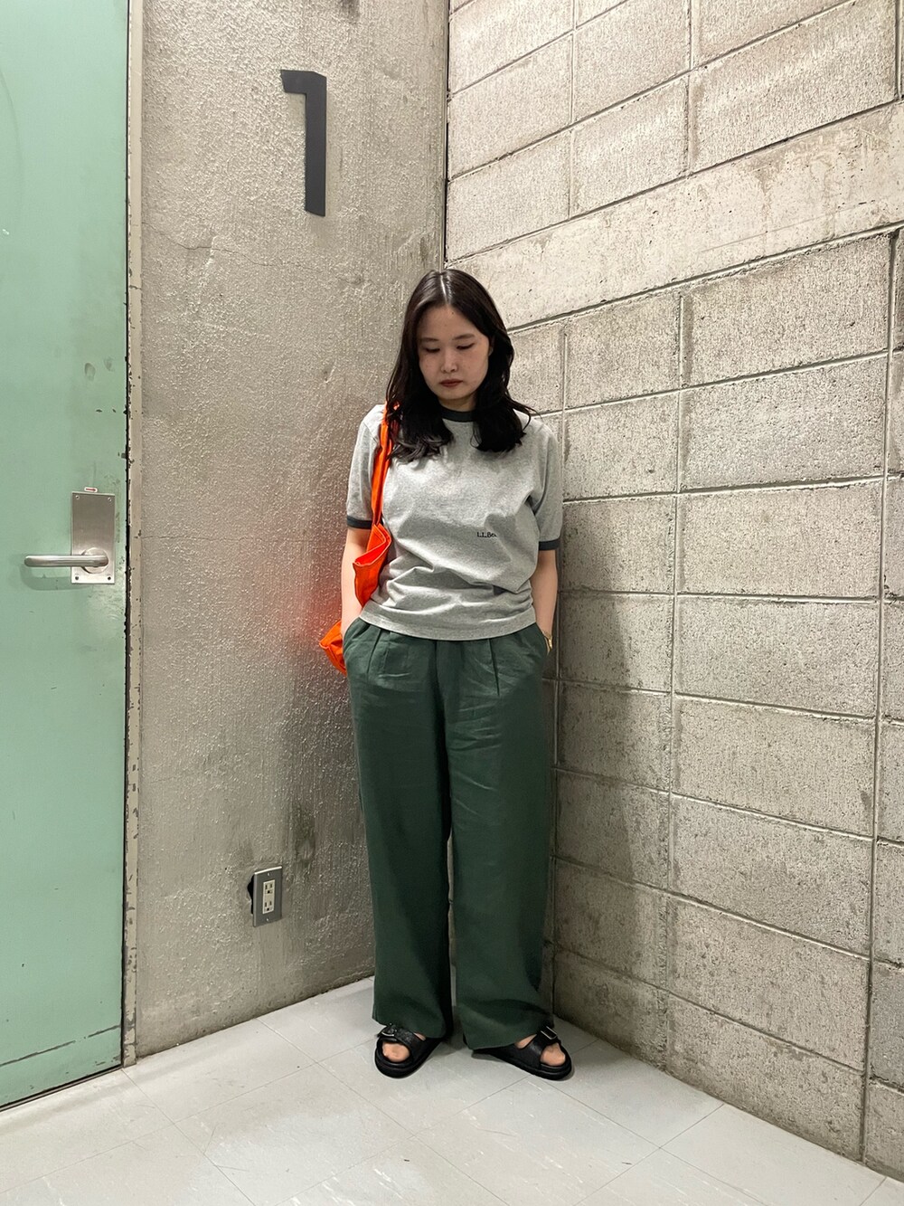 グレー系のTシャツ/カットソー、グリーン系のその他パンツ、ブラック系のサンダルを着用したレディースの春コーディネートの6枚目の写真