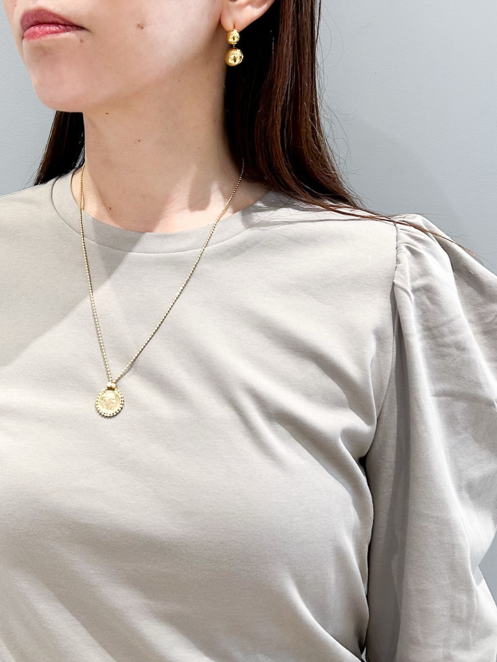 ブラウン系のスラックス、グレー系のTシャツ/カットソー、その他のハンドバッグを着用したレディースの秋コーディネートの7枚目の写真