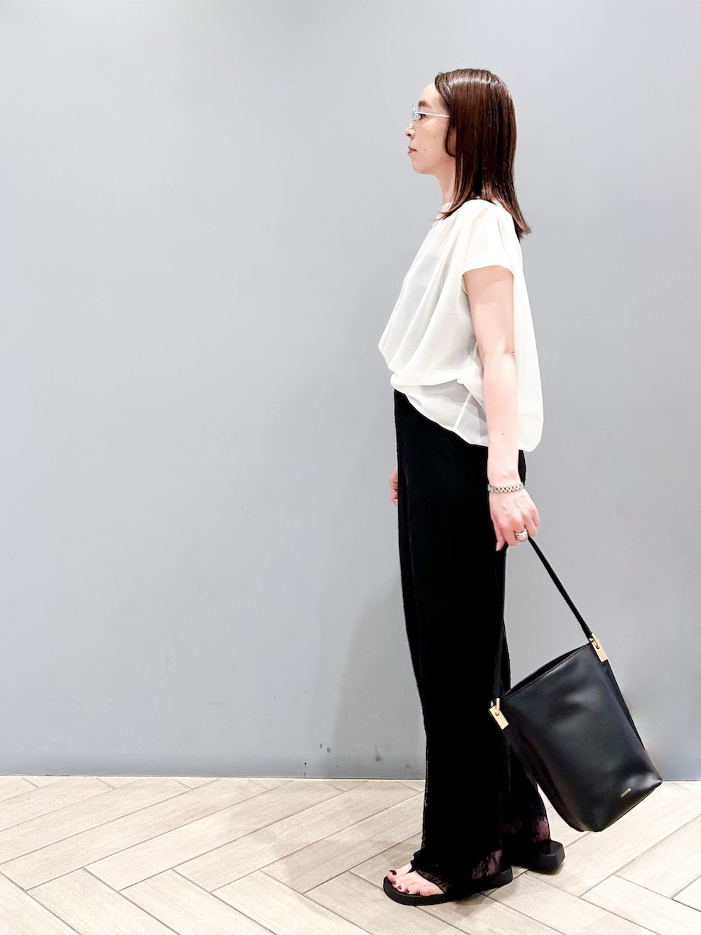 ブラック系のその他パンツ、ホワイト系のシャツ/ブラウス、ブラック系のショルダーバッグを着用したレディースの春コーディネートの3枚目の写真