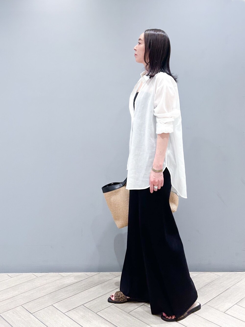 ブラック系のその他パンツ、ホワイト系のシャツ/ブラウス、ベージュ系のトートバッグを着用したレディースの春コーディネートの3枚目の写真