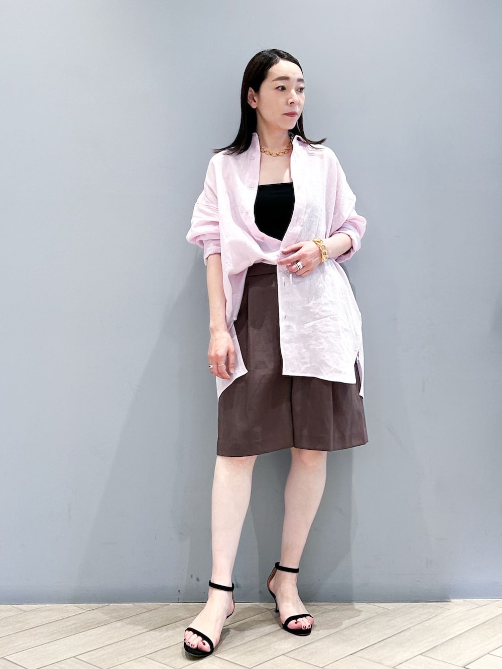 ブラウン系のその他パンツ、ピンク系のシャツ/ブラウス、ゴールド系のネックレスを着用したレディースの春コーディネートの2枚目の写真