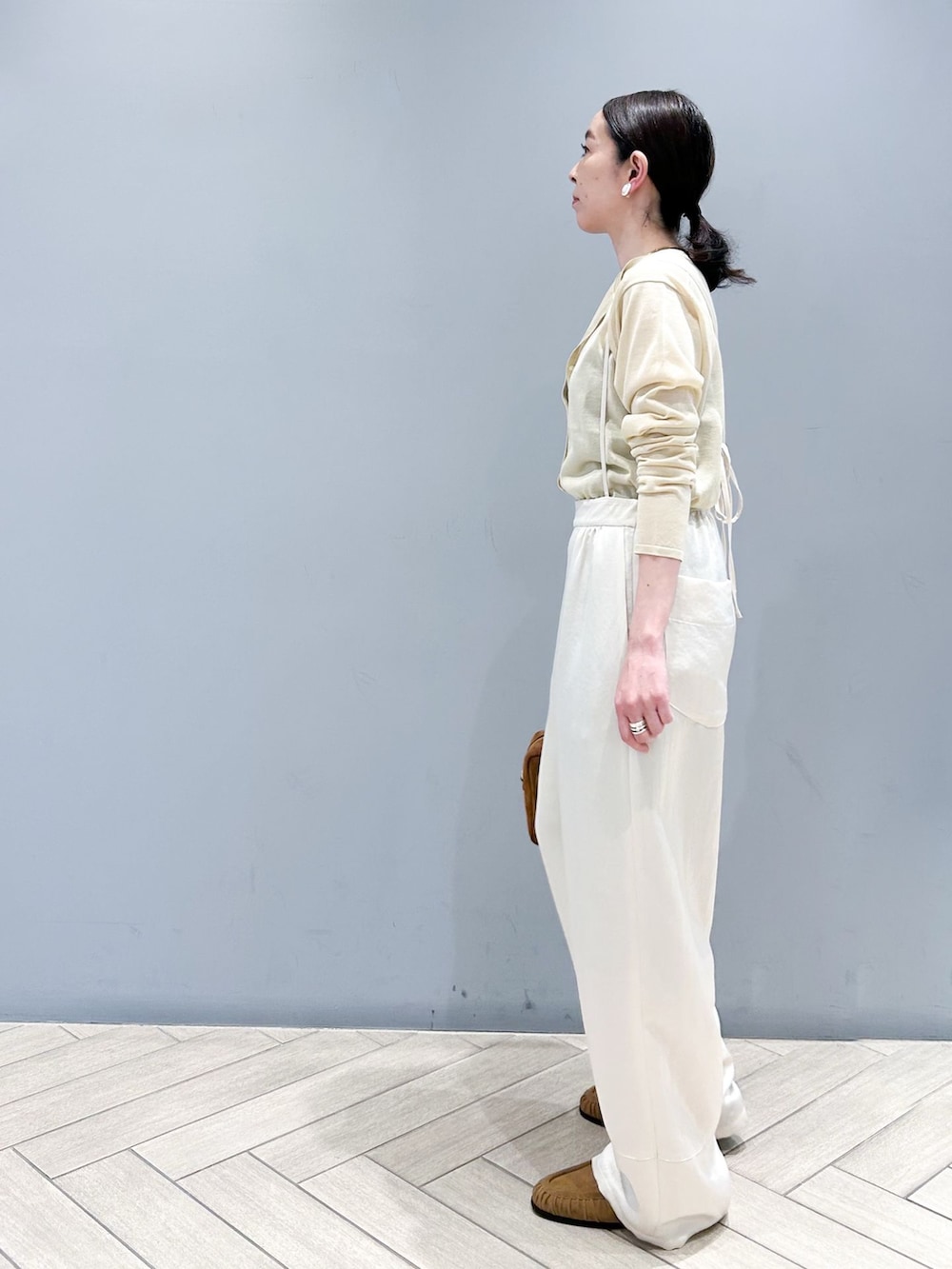 ホワイト系のその他パンツ、ベージュ系のカーディガン/ボレロ、ブラウン系のショルダーバッグを着用したレディースの春コーディネートの3枚目の写真