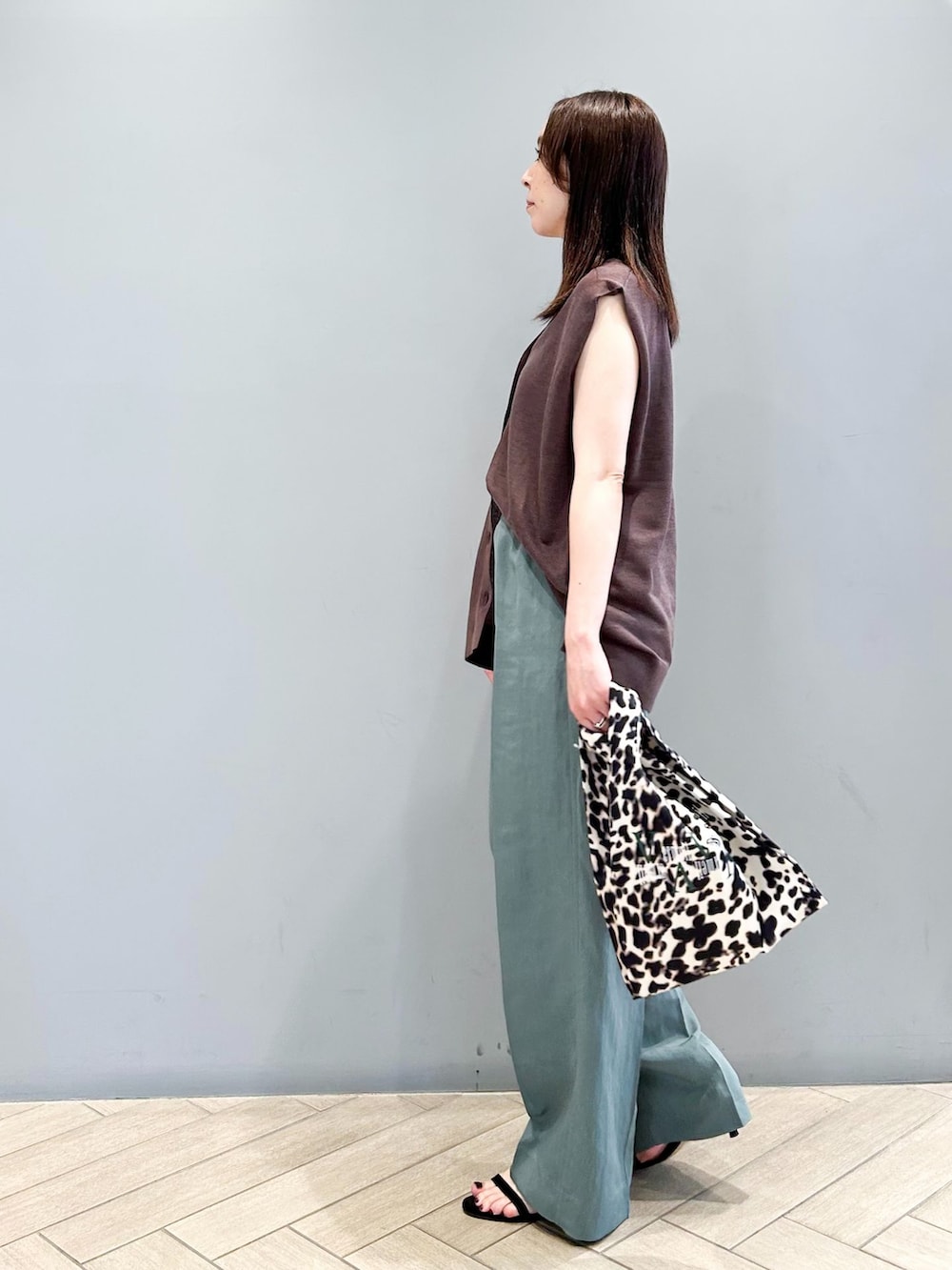 グリーン系のその他パンツ、ブラウン系のベスト、その他のエコバッグ/サブバッグを着用したレディースの夏コーディネートの3枚目の写真
