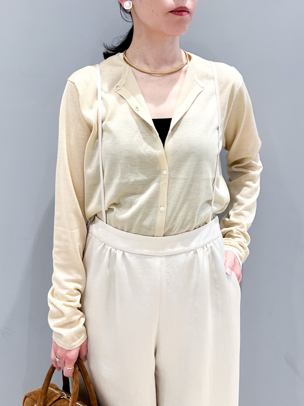 ホワイト系のその他パンツ、ベージュ系のカーディガン/ボレロ、ブラウン系のショルダーバッグを着用したレディースの春コーディネートの6枚目の写真