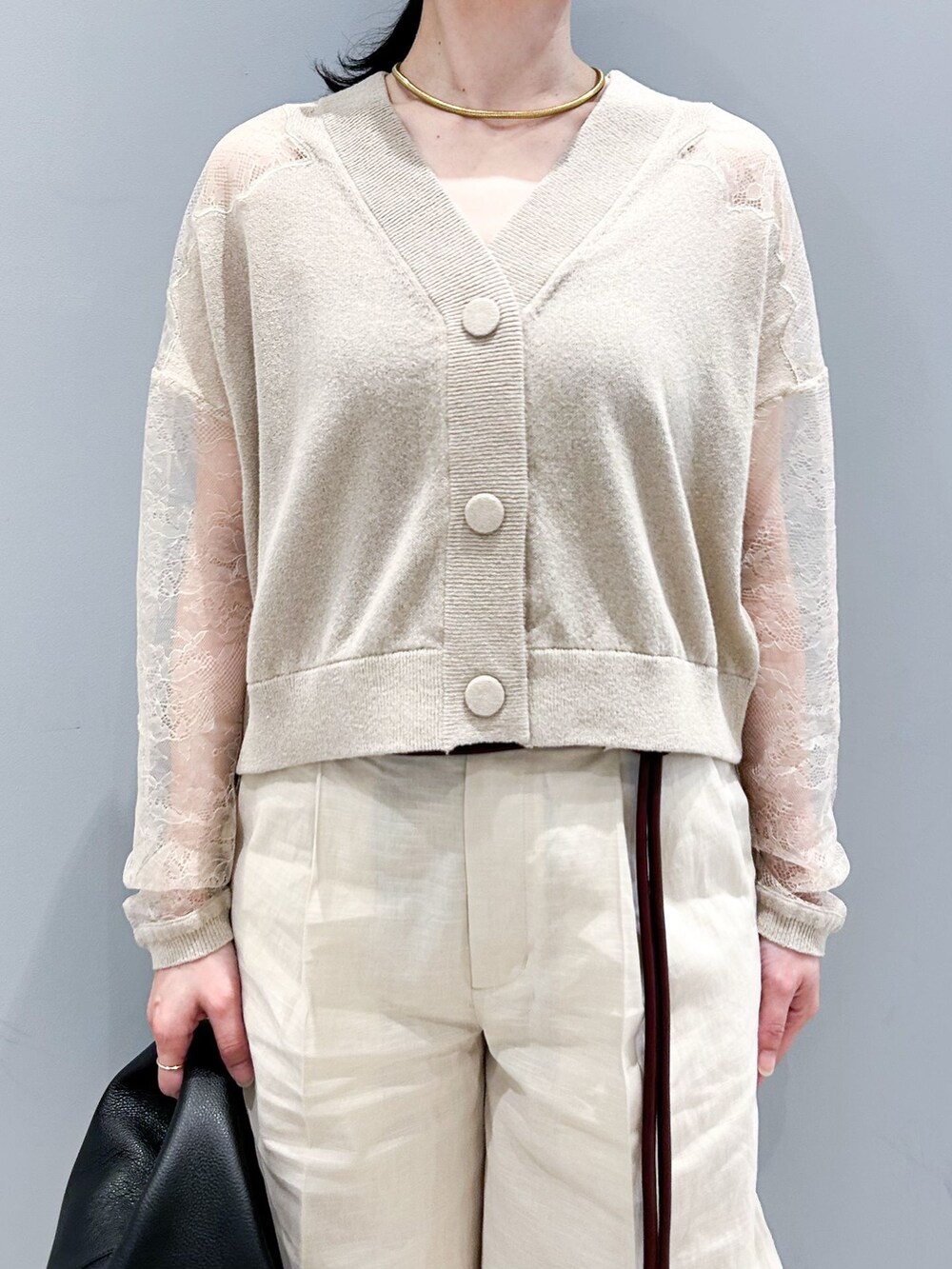 ベージュ系のその他パンツ、ベージュ系のカーディガン/ボレロ、ブラック系のハンドバッグを着用したレディースの春コーディネートの5枚目の写真