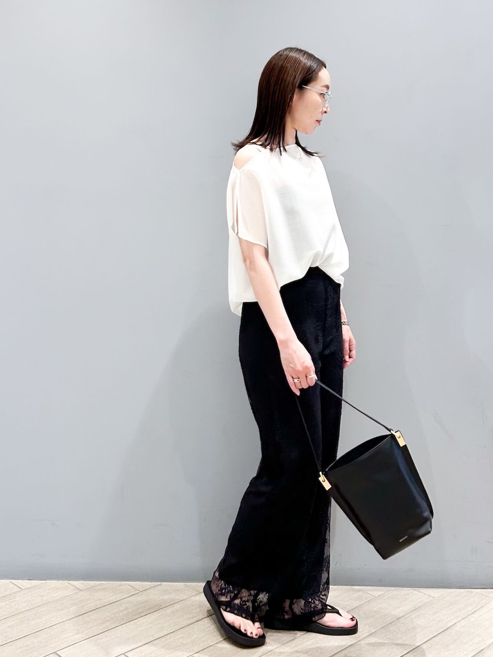 ブラック系のその他パンツ、ホワイト系のシャツ/ブラウス、ブラック系のショルダーバッグを着用したレディースの春コーディネートの5枚目の写真