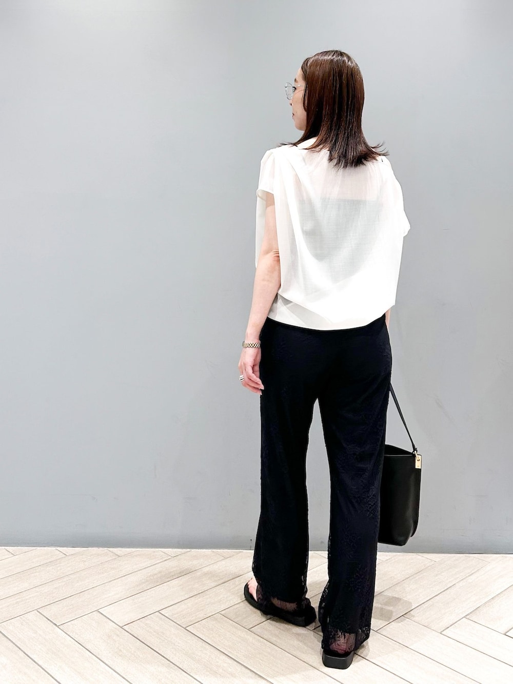 ブラック系のその他パンツ、ホワイト系のシャツ/ブラウス、ブラック系のショルダーバッグを着用したレディースの春コーディネートの4枚目の写真