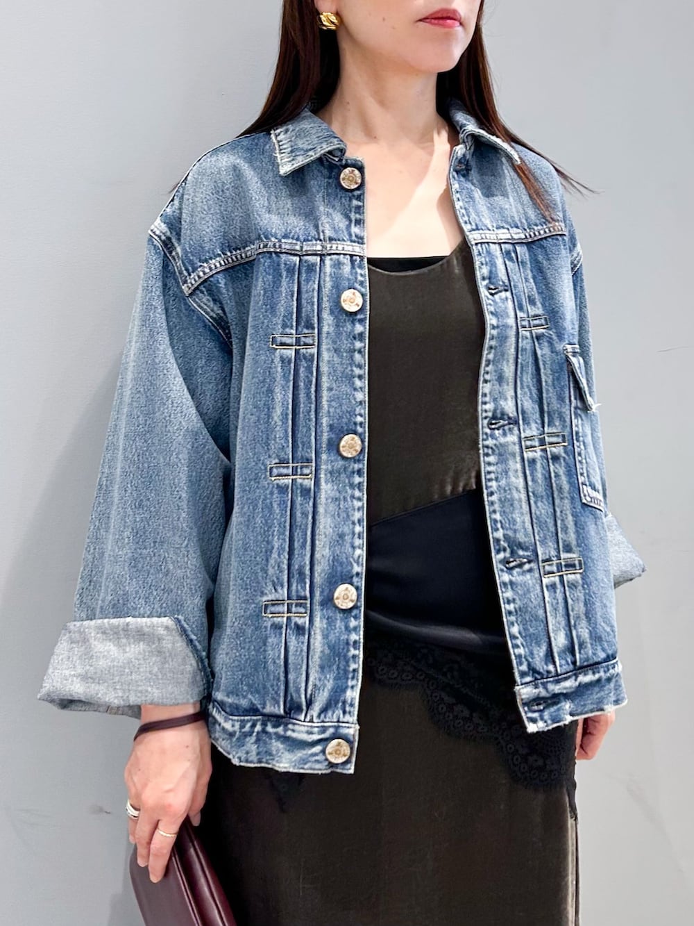 ブルー系のデニムジャケット、グレー系のワンピース、レッド系のクラッチバッグを着用したレディースの秋コーディネートの6枚目の写真