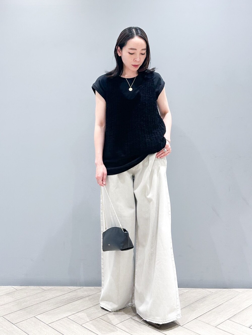 ブラック系のTシャツ/カットソー、ブラック系のタンクトップ、ブラック系のショルダーバッグを着用したレディースの春コーディネートの2枚目の写真