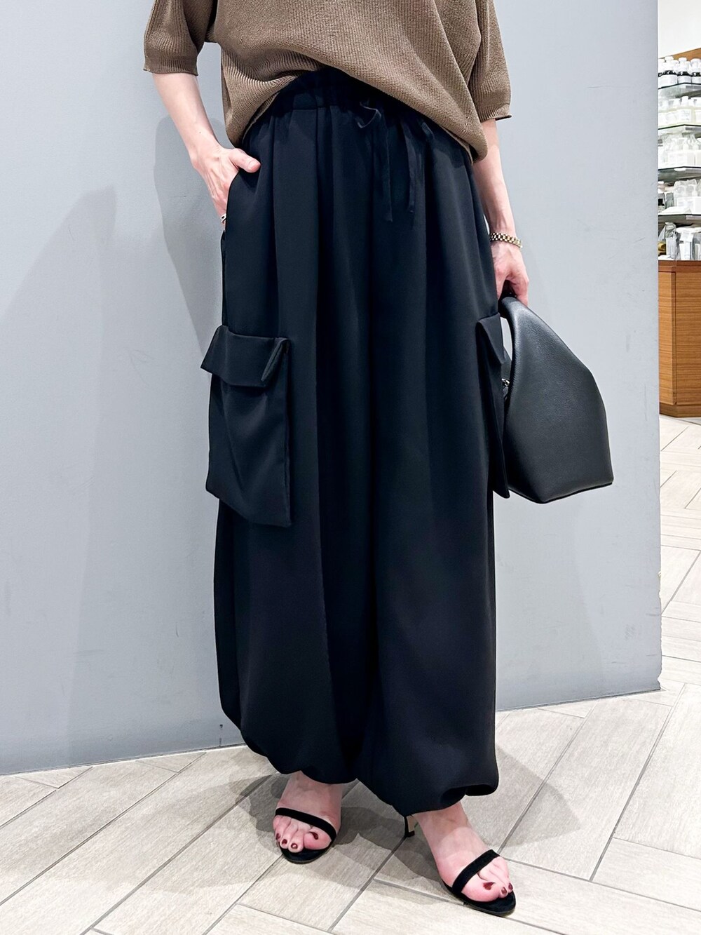 ブラック系のその他パンツ、ブラウン系のニット/セーター、ブラック系のハンドバッグを着用したレディースの春コーディネートの9枚目の写真