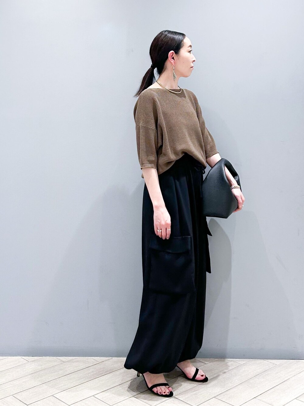 ブラック系のその他パンツ、ブラウン系のニット/セーター、ブラック系のハンドバッグを着用したレディースの春コーディネートの5枚目の写真