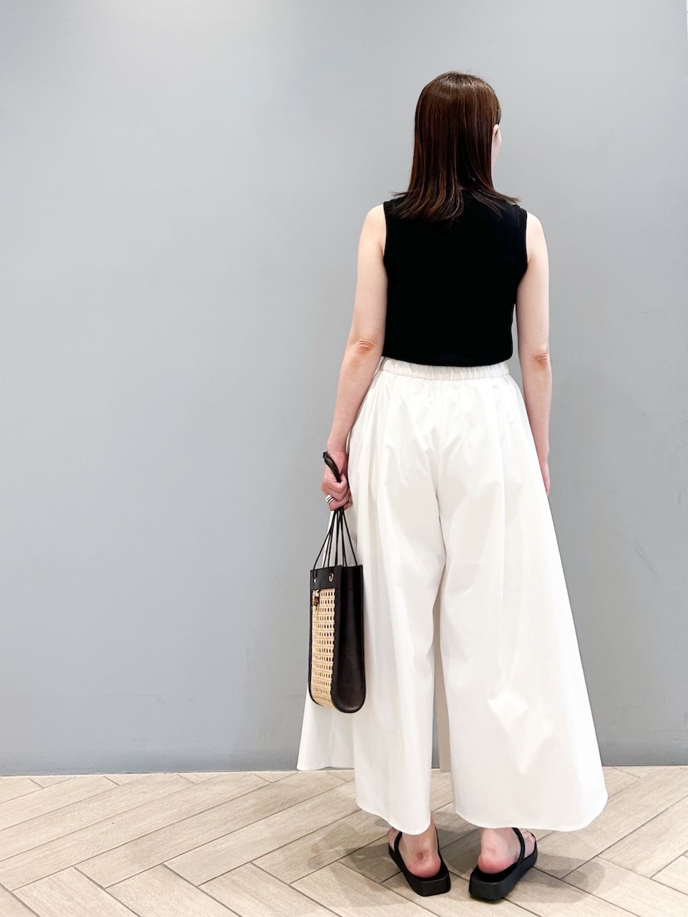 ホワイト系のその他パンツ、ブラック系のニット/セーター、ベージュ系のショルダーバッグを着用したレディースの春コーディネートの4枚目の写真