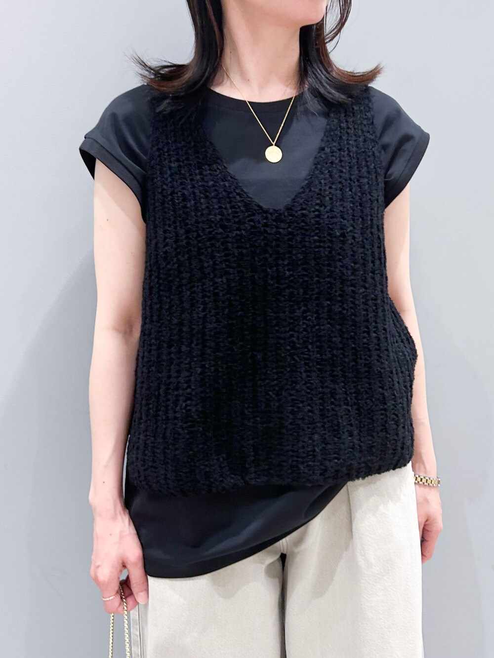 ブラック系のTシャツ/カットソー、ブラック系のタンクトップ、ブラック系のショルダーバッグを着用したレディースの春コーディネートの6枚目の写真