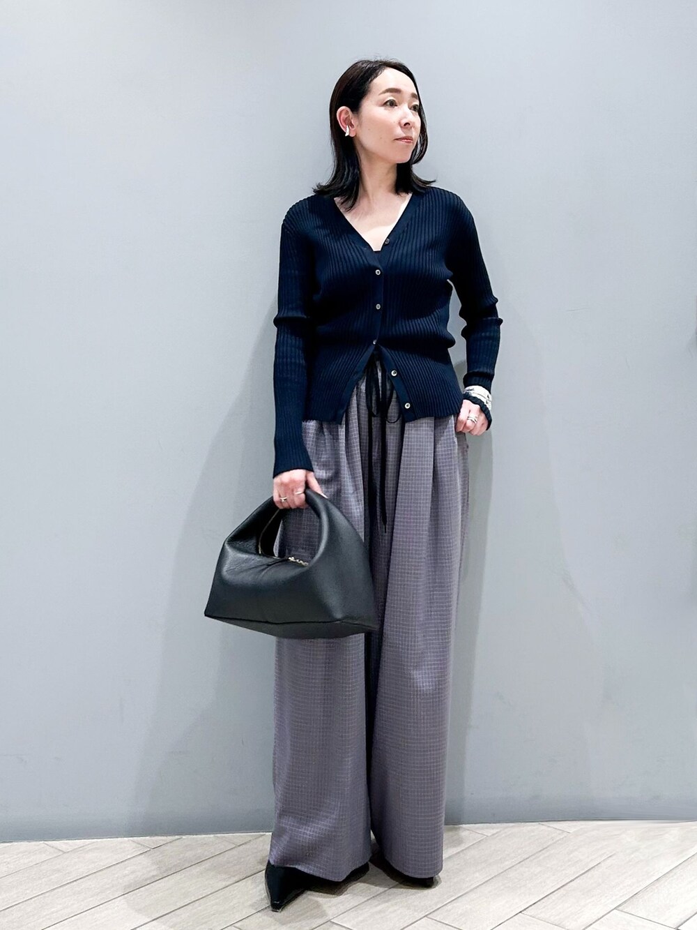 その他のその他パンツ、ブルー系のカーディガン/ボレロ、ブラック系のハンドバッグを着用したレディースの冬コーディネートの2枚目の写真
