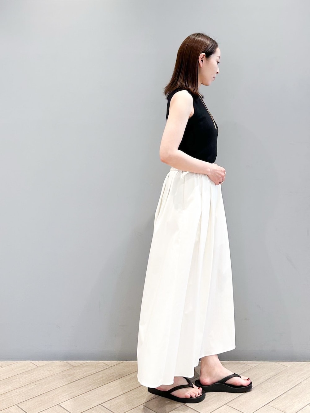 ホワイト系のその他パンツ、ブラック系のニット/セーター、ベージュ系のショルダーバッグを着用したレディースの春コーディネートの5枚目の写真