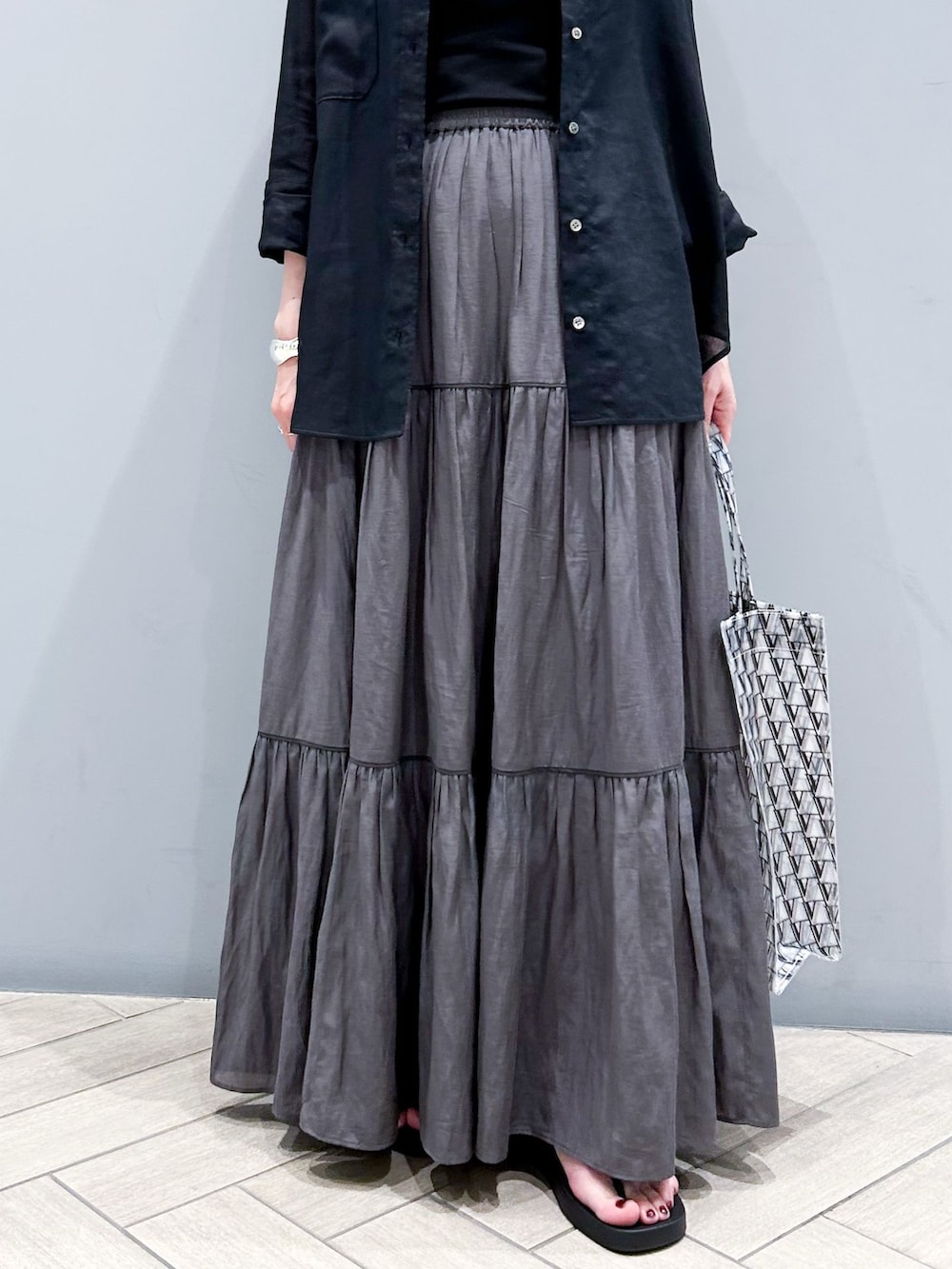 ブラック系のシャツ/ブラウス、グレー系のスカート、ブラック系のサンダルを着用したレディースの夏コーディネートの8枚目の写真