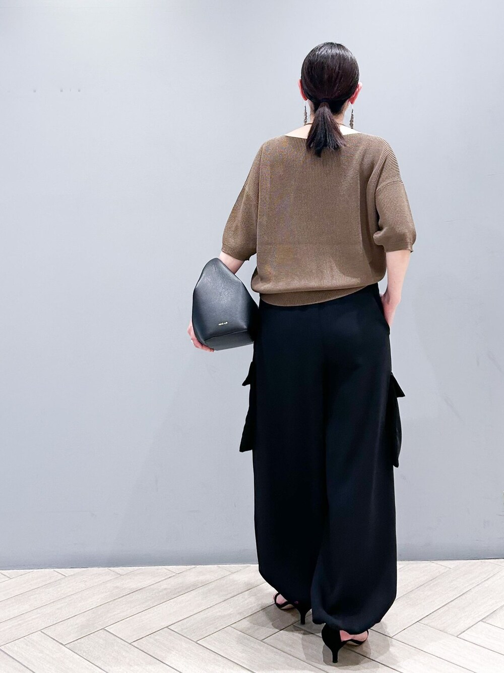 ブラック系のその他パンツ、ブラウン系のニット/セーター、ブラック系のハンドバッグを着用したレディースの春コーディネートの4枚目の写真