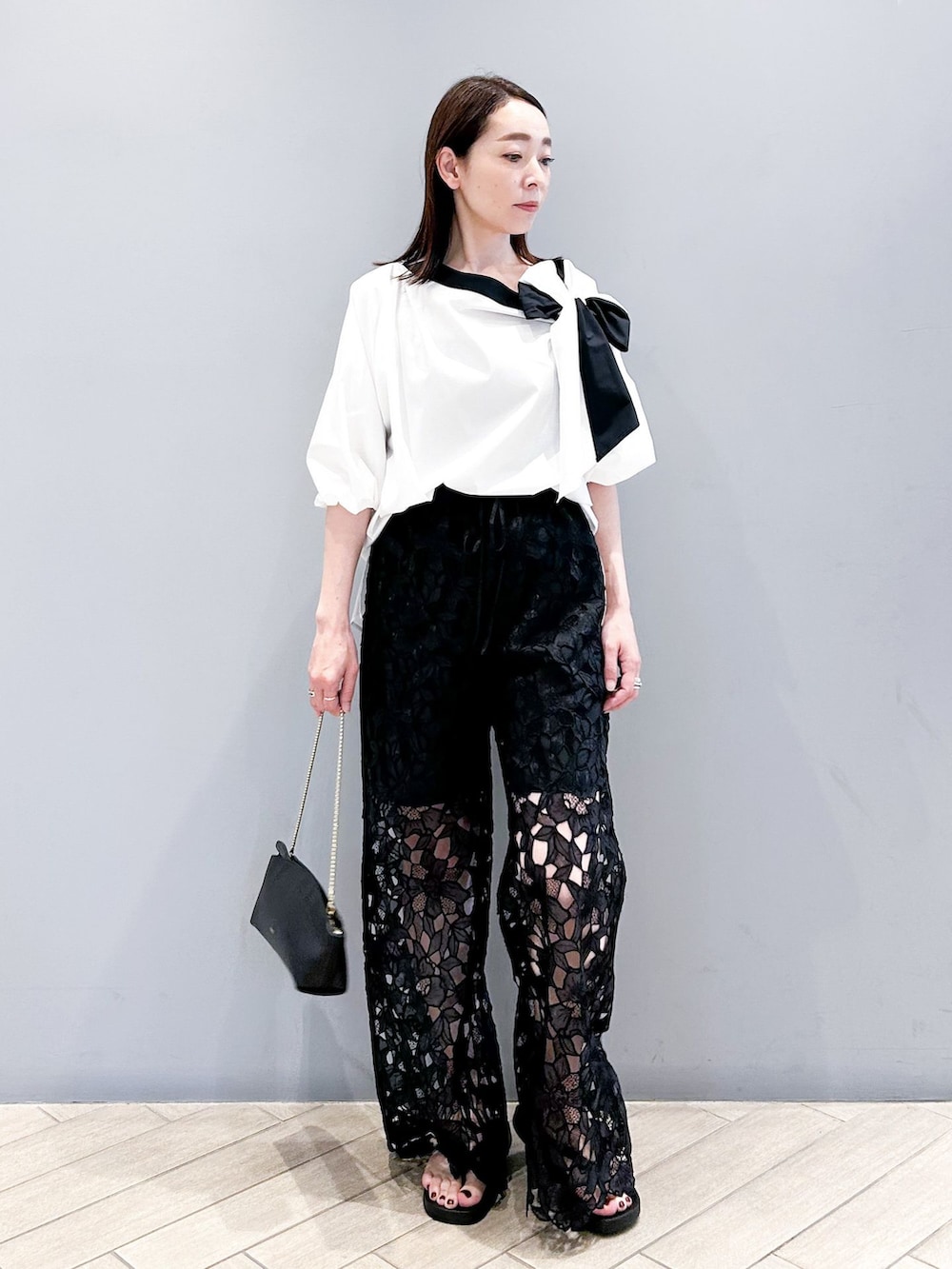 ブラック系のその他パンツ、ホワイト系のシャツ/ブラウス、ブラック系のショルダーバッグを着用したレディースの春コーディネートの3枚目の写真