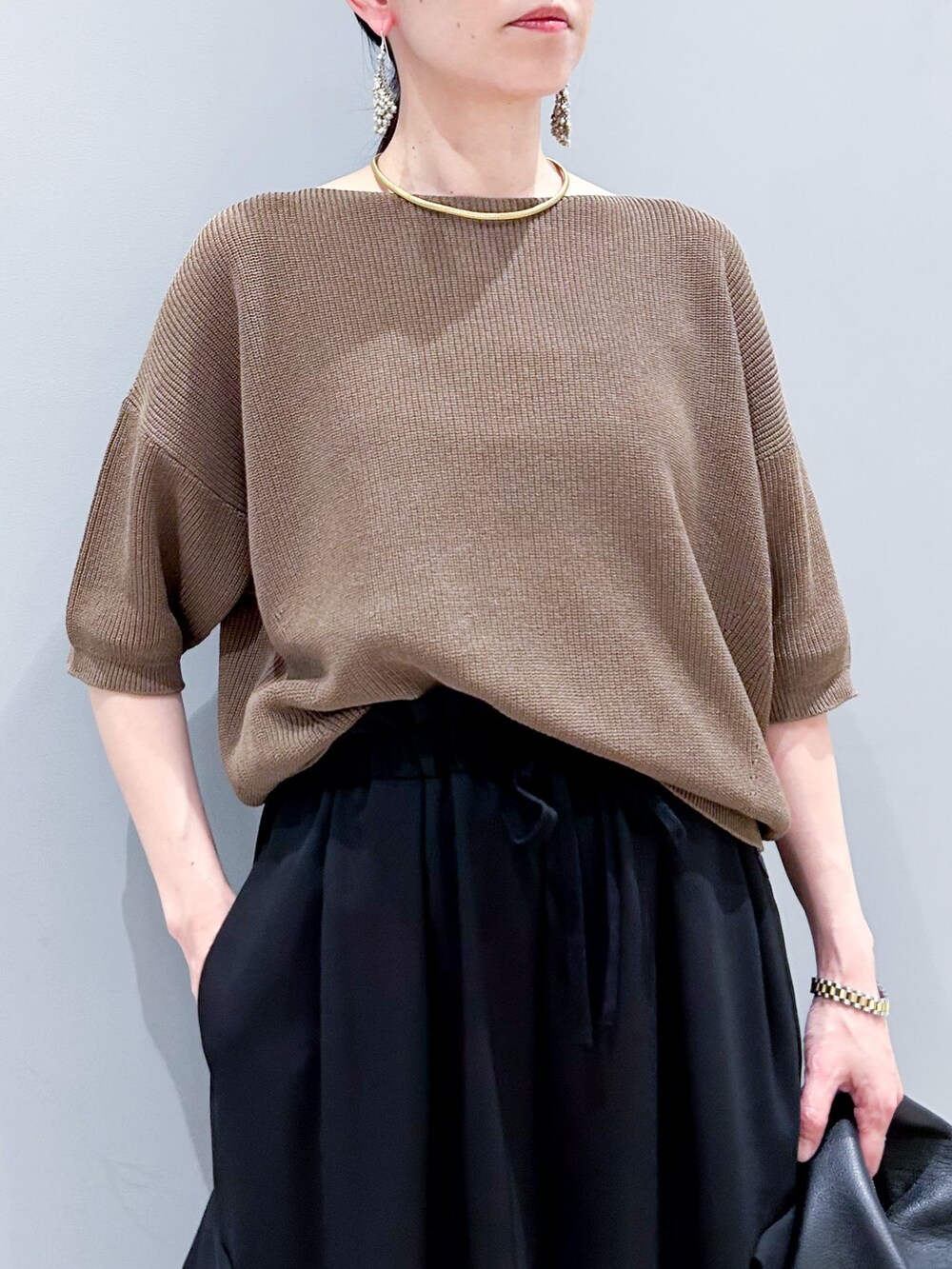 ブラック系のその他パンツ、ブラウン系のニット/セーター、ブラック系のハンドバッグを着用したレディースの春コーディネートの6枚目の写真