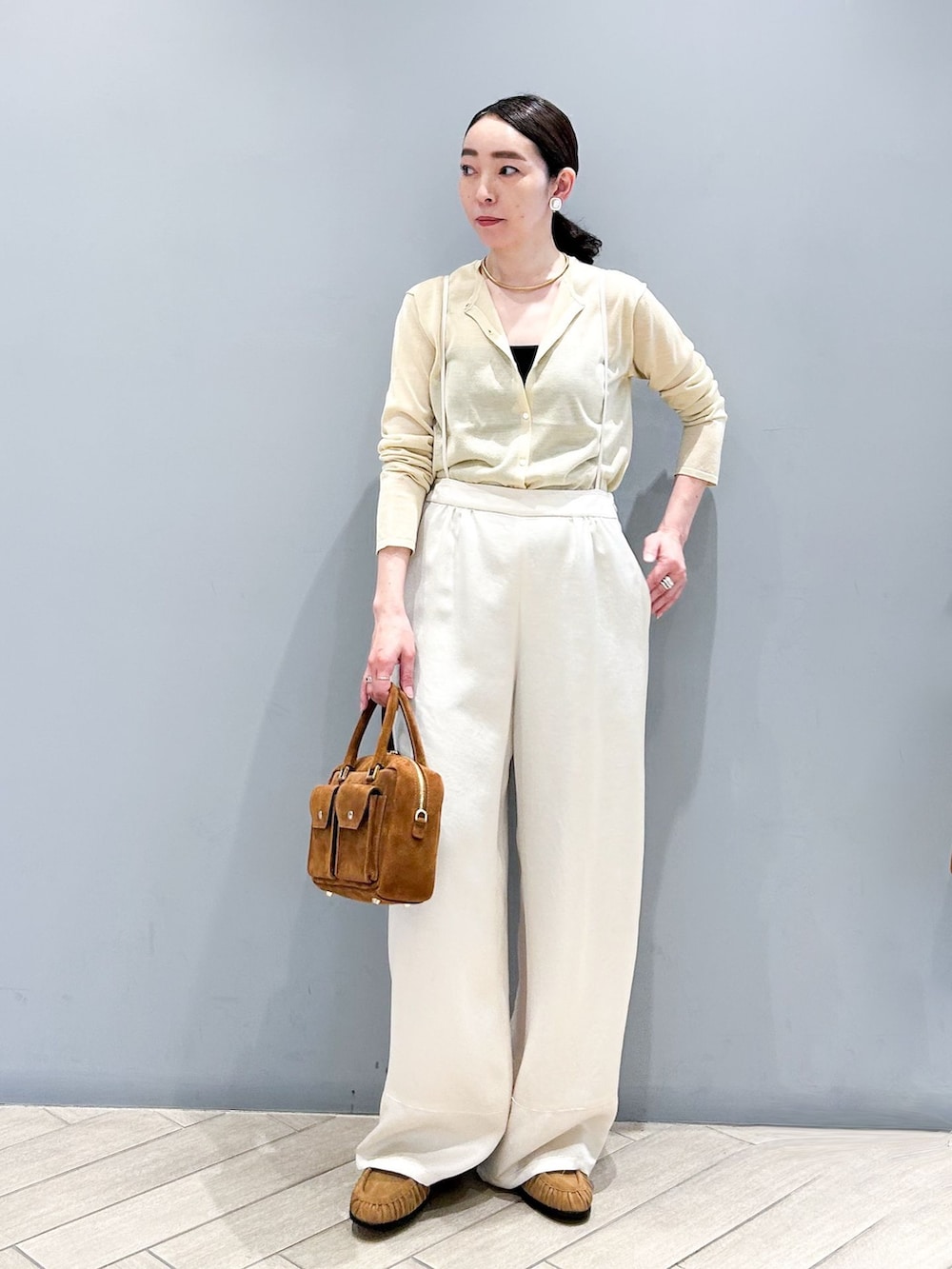 ホワイト系のその他パンツ、ベージュ系のカーディガン/ボレロ、ブラウン系のショルダーバッグを着用したレディースの春コーディネートの2枚目の写真