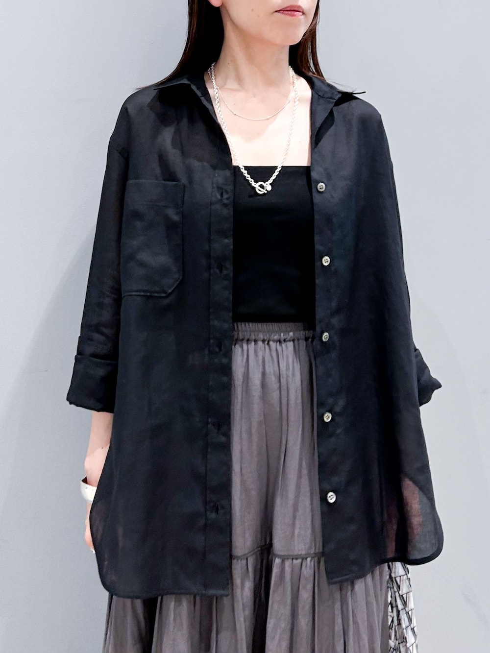 ブラック系のシャツ/ブラウス、グレー系のスカート、ブラック系のサンダルを着用したレディースの夏コーディネートの6枚目の写真