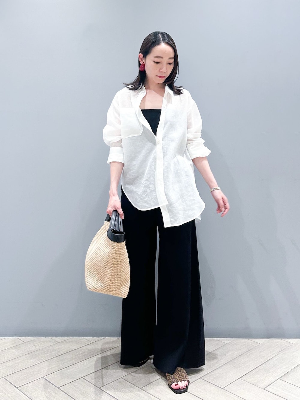 ブラック系のその他パンツ、ホワイト系のシャツ/ブラウス、ベージュ系のトートバッグを着用したレディースの春コーディネートの2枚目の写真